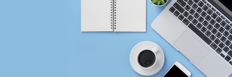 Computer with notebook and a cup of coffee