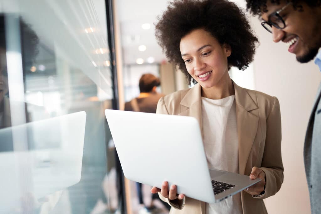 Woman showing her coworker her laptop