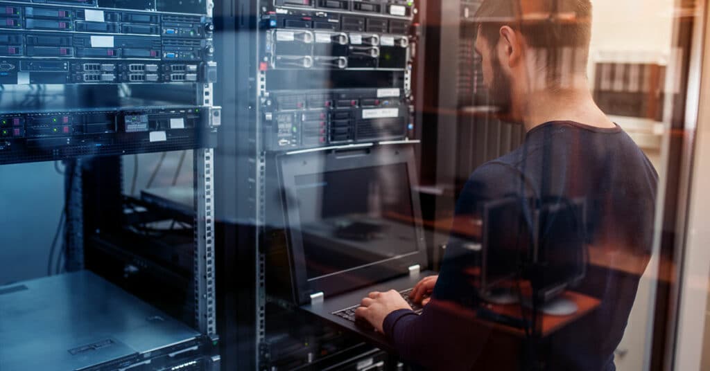 Man working on a computer in a server room