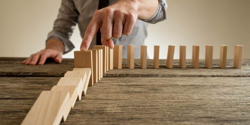 Businessman stoping blocks falling