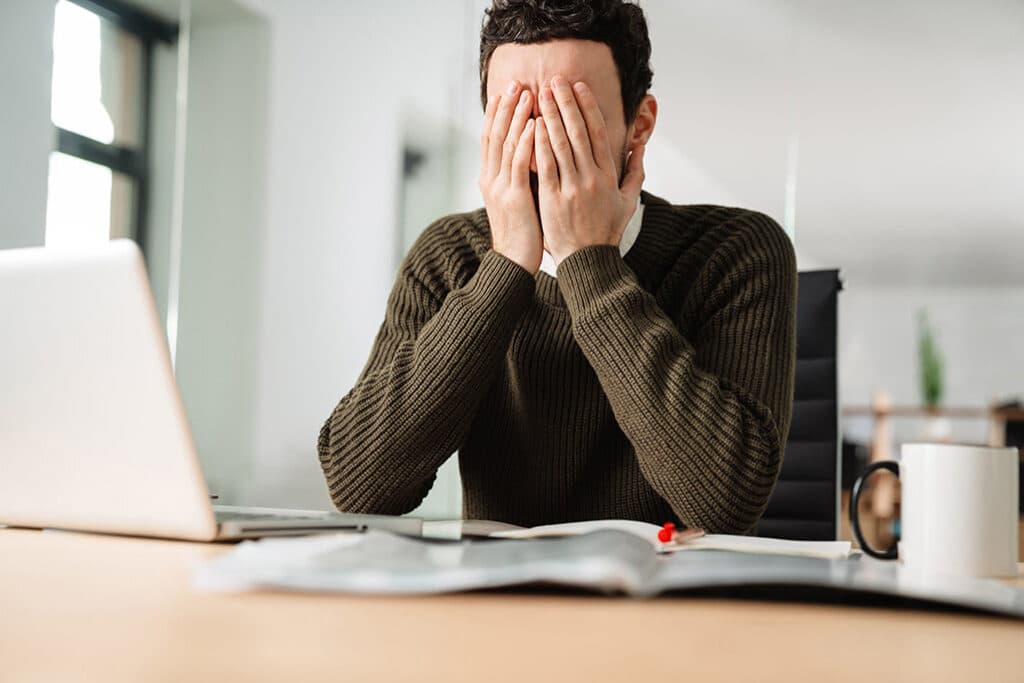 Man with heads in his hands acting stressed