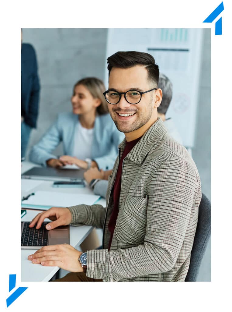 smiling IT specialist working on a laptop