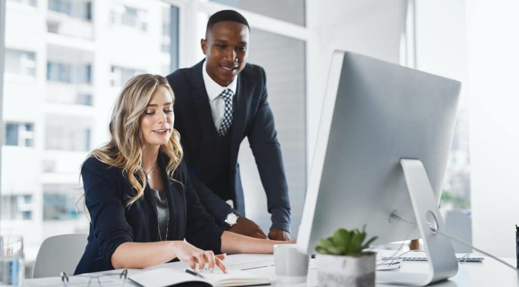two coworkers working on task at computer