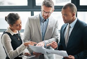 Banking professionals collaborating on IT compliance and security documentation review